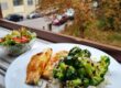 a white plate topped with rice and broccoli next to a bowl of salad
