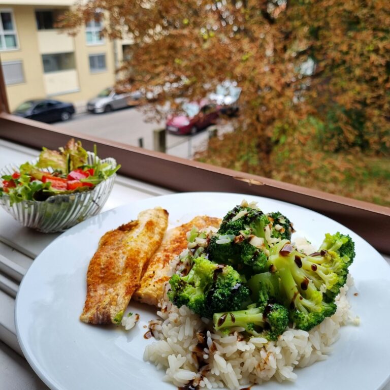 a white plate topped with rice and broccoli next to a bowl of salad
